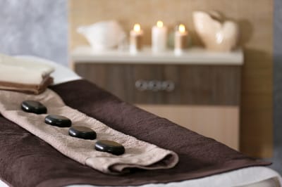Wellness spa setup with stones and candles.