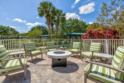 Outdoor seating area with green chairs and plants