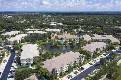 Aerial view of a large senior living campus with gardens and water features