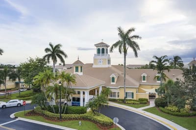 Exterior view of a senior living facility with palm trees