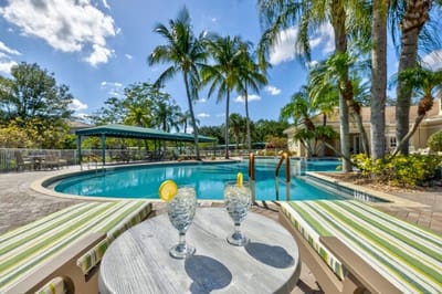 Poolside seating with drinks and palm trees