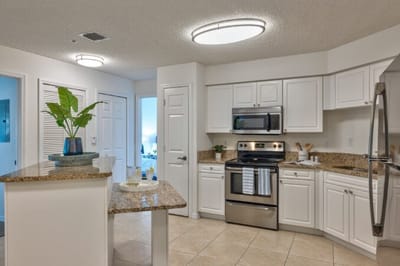 Bright, modern kitchen with white cabinets and stainless steel appliances