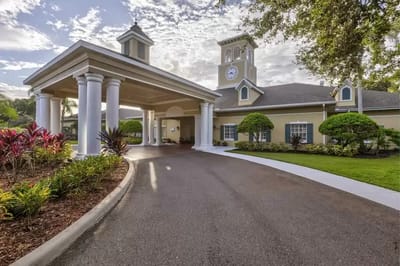 Exterior view of a senior living facility with gardens and entrance