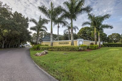 Entrance to a senior living facility with palm trees