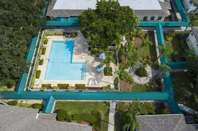 Aerial view of a pool area surrounded by gardens