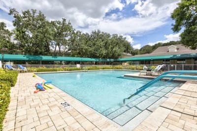 Swimming pool with lounge chairs and greenery