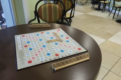 A Scrabble game set up on a table in a common area