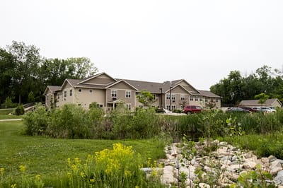 Exterior view of the assisted living facility surrounded by greenery