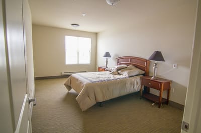 A private resident room with a bed and lamps