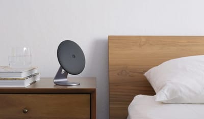 A bedside table with a lamp and a glass of water