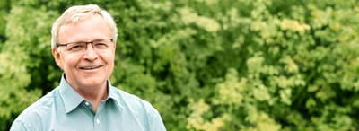 Smiling man outdoors with green background