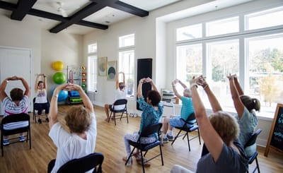 Residents participating in a seated exercise class