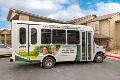 Facility shuttle bus with smiling residents on the side