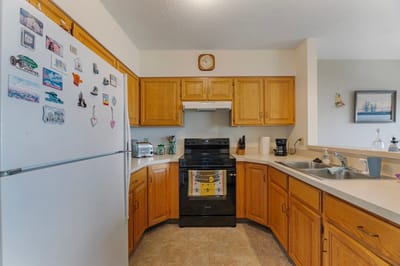 Cozy kitchen area with wooden cabinets and appliances