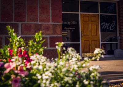 Leasing office entrance with flowers in foreground