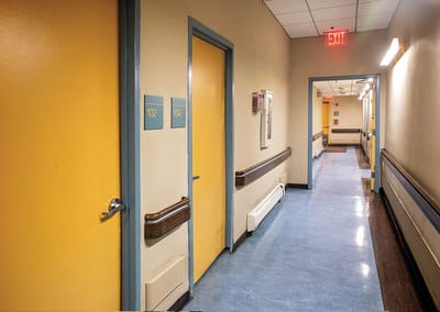 Brightly lit hallway with resident rooms