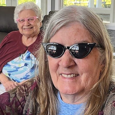 Two smiling residents posing together indoors