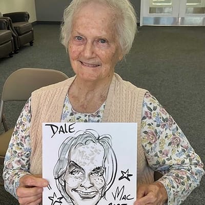 Resident holding a caricature drawing in a common area