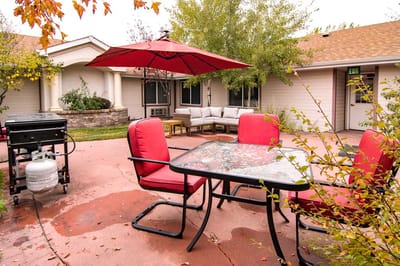 Outdoor seating area with red chairs and umbrella