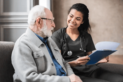 Epworth Villa Health Services, Nursing Home in Oklahoma City, OK — Healthcare professional discussing with senior resident