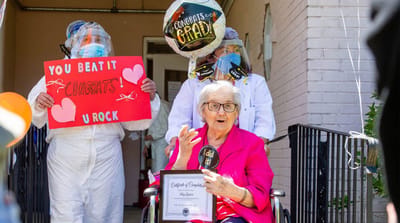 Resident celebrating graduation with staff and decorations