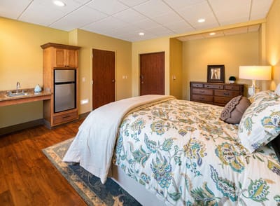 Bright, well-furnished resident room with a queen bed