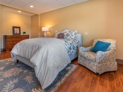 Cozy private resident room with a bed and armchair