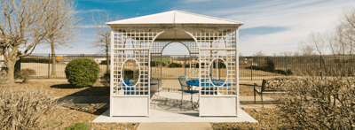 Outdoor gazebo with seating in a landscaped area