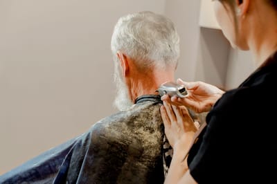 Resident receiving a haircut in a salon setting