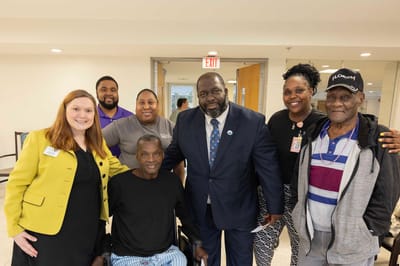 Staff and residents posing for a group photo in a common area
