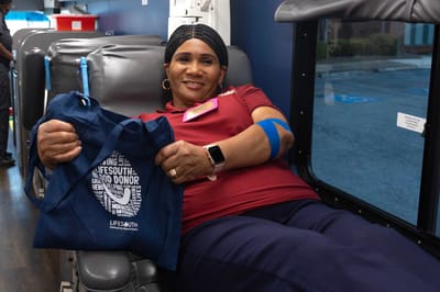 A staff member donating blood inside a facility van