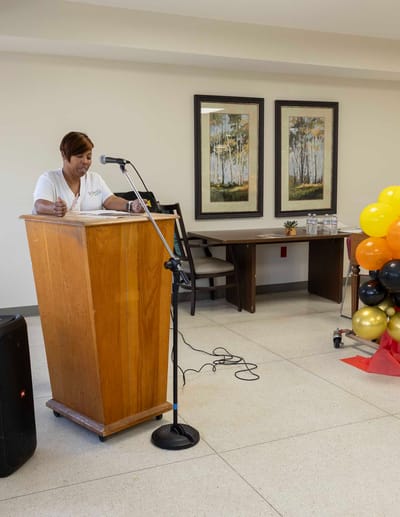 Staff member speaking at an event in a common area