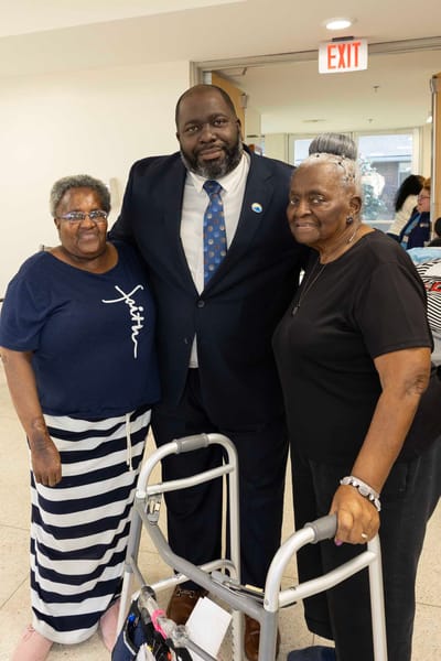 Residents with staff member in facility interior