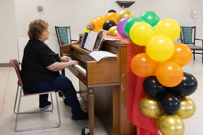 Resident performing music on a piano during a celebration