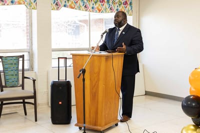 A speaker addressing residents in a well-lit common area