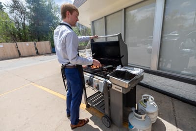 Staff member grilling outside at a BBQ event