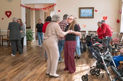 Residents dancing together in the activity room