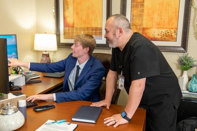 Staff assisting each other at a desk in an office