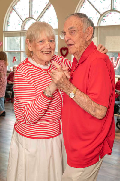 Two residents dancing during a celebration in the activity room