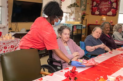 Staff member serving residents during Valentine's Day celebration