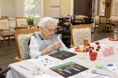 A resident painting in an activity room