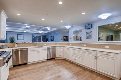 Modern kitchen area with white cabinetry and appliances