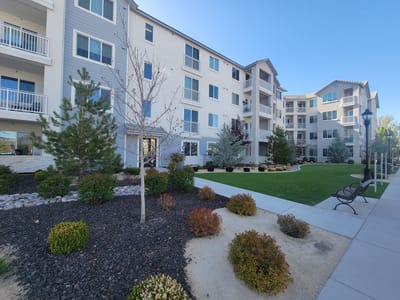 Exterior view of a senior living facility with landscaped garden