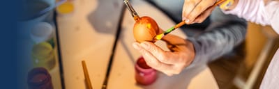 A resident painting an Easter egg during an activity