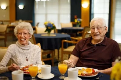 Two residents enjoying breakfast in a common area