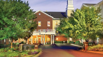 Exterior view of a residential care facility with lush landscaping
