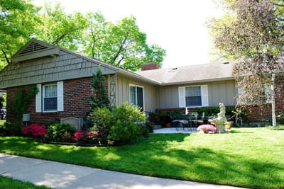 Exterior view of a senior living facility with garden