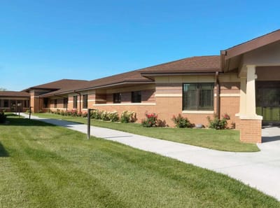 Exterior view of a senior living facility with gardens