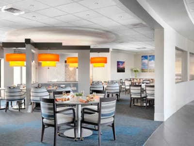 Bright dining room with modern decor and tables set for meals