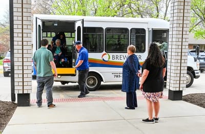 Residents boarding a facility transport vehicle